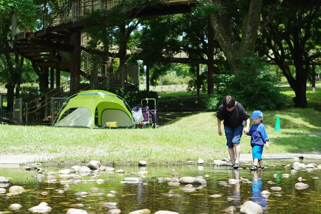 アウトドアサンダルを履いて川で遊ぶ親子